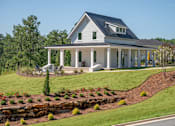 Thumbnail 44 of 67 - A white house with a black roof and a porch.
