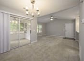 Thumbnail 7 of 23 - A room with a chandelier, sliding glass doors, and a carpeted floor.