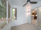 Thumbnail 10 of 23 - A room with a ceiling fan and sliding glass doors.