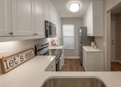 Thumbnail 3 of 23 - A kitchen with a sign that says "let's eat" on the counter.
