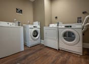 Thumbnail 23 of 33 - Three front load washing machines in a laundry room.