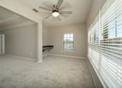 Thumbnail 18 of 48 - A room with a ceiling fan and a window with blinds.