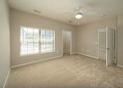 Thumbnail 17 of 48 - A room with a ceiling fan and a door.