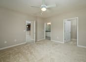 Thumbnail 29 of 48 - A room with a ceiling fan and carpeted floor.