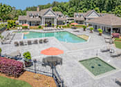 Thumbnail 1 of 32 - A large house with a pool and a patio area.