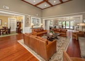 Thumbnail 7 of 37 - A large brown leather couch sits in the middle of a spacious living room.