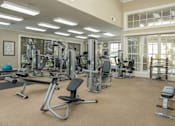 Thumbnail 6 of 37 - A spacious gym with a variety of equipment including treadmills, weight machines, and free weights.