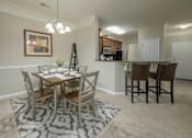 Thumbnail 26 of 37 - A dining room with a table set for four.