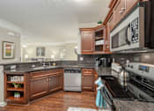 Thumbnail 31 of 37 - A kitchen with a black counter top and a black stove top oven.
