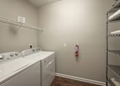 Thumbnail 36 of 37 - A laundry room with a washer and dryer.