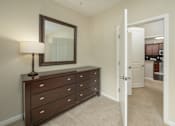 Thumbnail 33 of 37 - A brown dresser with a mirror above it and a lamp on top.
