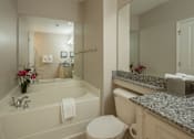 Thumbnail 30 of 37 - A white bathroom with a tub, toilet, and sink.