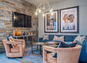 Thumbnail 16 of 25 - A living room with a stone wall and a blue couch.