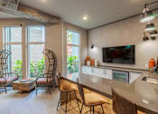 Thumbnail 14 of 25 - A modern kitchen with a bar area and chairs.