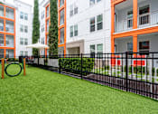 Thumbnail 22 of 25 - A playground area with a green slide and a black fence.