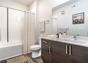 Thumbnail 21 of 40 - A bathroom with a white tub, sink, and toilet.