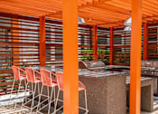 Thumbnail 35 of 40 - A patio with orange pillars and a table with chairs.