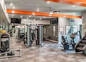 Thumbnail 24 of 40 - A gym with a variety of equipment including treadmills, weights, and exercise machines.