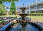 Thumbnail 24 of 30 - a fountain in a park with a building in the background