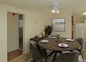 Thumbnail 9 of 49 - A dining room with a table set for two and a potted plant.