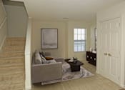 Thumbnail 12 of 49 - A living room with a couch, a coffee table, and a painting on the wall.