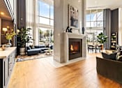 Thumbnail 61 of 72 - A modern living room with a fireplace and a large window.