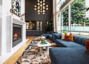 Thumbnail 62 of 72 - A living room with a fireplace and a blue couch.