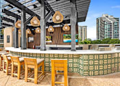Thumbnail 52 of 72 - A bar with wooden chairs and a green patterned wall.