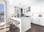Thumbnail 21 of 80 - A modern kitchen with white cabinets and a large island.
