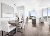 Thumbnail 22 of 80 - A modern dining room with a wooden table and white chairs.