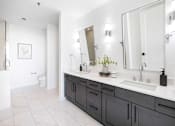 Thumbnail 28 of 80 - A bathroom with a white sink and a large mirror.