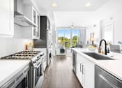 Thumbnail 35 of 80 - A modern kitchen with a stove top oven and a dishwasher.