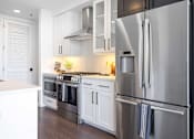 Thumbnail 62 of 80 - A modern kitchen with stainless steel appliances and white cabinets.