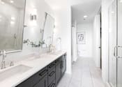 Thumbnail 48 of 80 - A bathroom with a white sink and a large mirror.