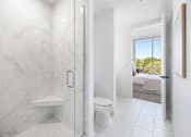 Thumbnail 68 of 80 - A white bathroom with a walk-in shower and a toilet.