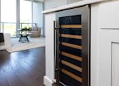 Thumbnail 37 of 80 - A modern kitchen with a white cabinet and a black and gold fridge.