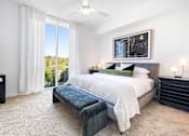Thumbnail 47 of 80 - Luxury Apartments In Buckhead, GA With In-Unit Washer And Dryer - The Huntley - Spacious Bedroom With Plush Carpeting, A Ceiling Fan, And Floor-to-Ceiling Window Walls With Double Sliders And Mecho® Shades.