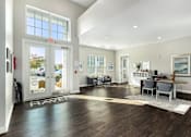 Thumbnail 15 of 26 - A spacious room with a wooden floor and a white rug in the center.