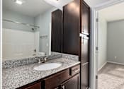 Thumbnail 13 of 26 - A bathroom with a sink, mirror, and cabinets.