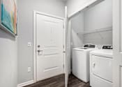Thumbnail 7 of 26 - A white door is open to a laundry room with a washer and dryer.