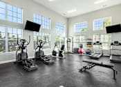 Thumbnail 20 of 26 - A spacious home gym with treadmills, elliptical machines, and a weight bench.