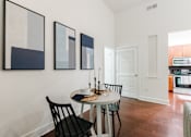 Thumbnail 16 of 28 - A dining room with a table and chairs.