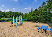 Thumbnail 28 of 28 - A playground with a blue table and a swing set.