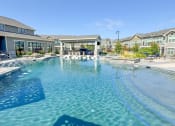 Thumbnail 19 of 50 - a large swimming pool with apartments in the background