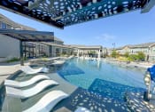 Thumbnail 18 of 50 - a large swimming pool with lounge chairs and a building in the background