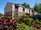 Thumbnail 34 of 38 - an apartment building with a car parked in front of it