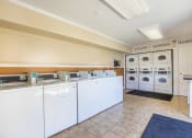 Thumbnail 30 of 38 - a laundry room with washers and dryers and a counter with washing machines