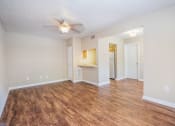 Thumbnail 29 of 38 - an empty living room with a ceiling fan and a bathroom