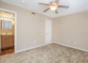 Thumbnail 26 of 38 - an empty living room with a ceiling fan and a bathroom