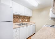 Thumbnail 13 of 30 - A kitchen with white cabinets and a white refrigerator.